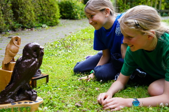 Children looking at the schools quiz trophies