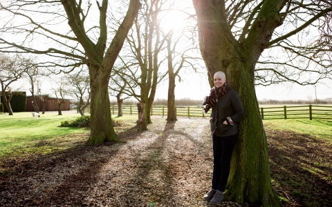 Michelle stands beside a tree