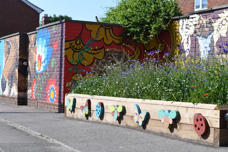 An image of a planter and the mural on Barton Street.