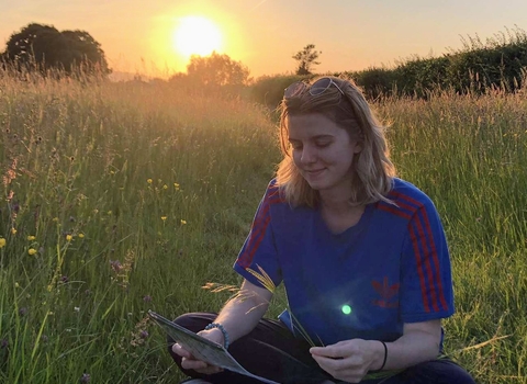 Josie in a field identifying grasses